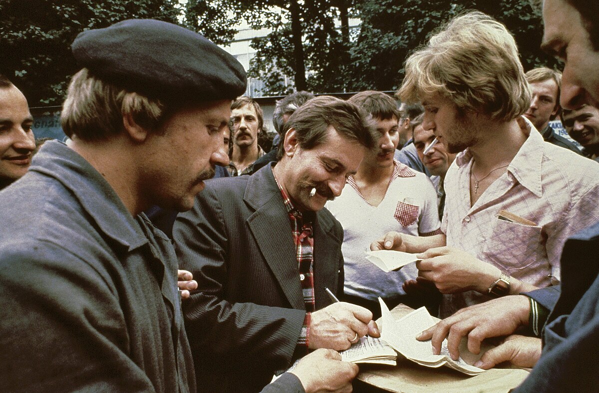 https://en.wikipedia.org/wiki/File:Stakingsleider_Lech_Walesa_deelt_handtekeningen_uit,_Bestanddeelnr_253-8300.jpg